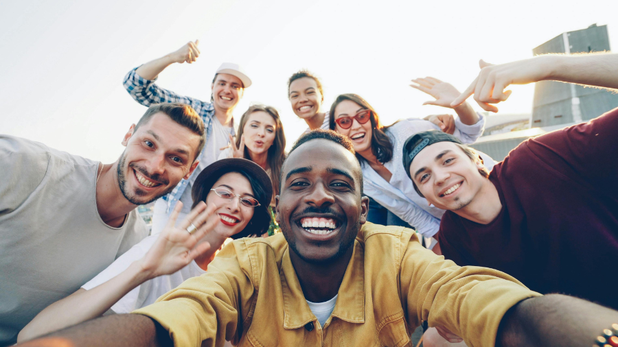 Group of smiling friends taking a selfie outdoors